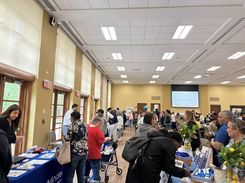 “This image from the Spring Into Wellness event held on May 15 shows an attendee receiving guidance at a resource table providing information on household and community support programs.”