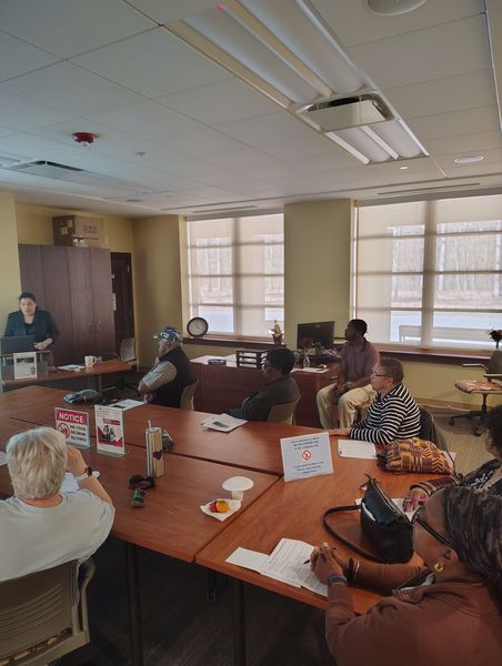 Photo of a computer class in Room 109 taught by instructor Diomaris Gomez, showing participants seated at tables during a lesson on confident internet browsing held on April 14 at 11 p.m., with desktop computers visible around the room.