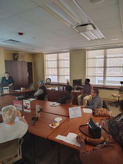 Photo of a computer class in Room 109 taught by instructor Diomaris Gomez, showing participants seated at tables during a lesson on confident internet browsing held on April 14 at 11 p.m., with desktop computers visible around the room.