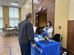 This image from the Spring Into Wellness event held on May 15 shows a table providing Medicare and insurance‑related information, brochures, and assistance resources.