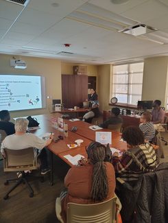 Photo of a computer class in Room 109 taught by instructor Diomaris Gomez, showing participants seated at tables during a lesson on confident internet browsing held on April 14 at 11 p.m., with desktop computers visible around the room.