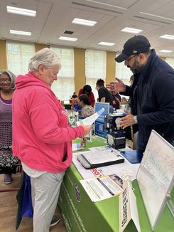 This image from the Spring Into Wellness event held on May 15 features a healthcare services table sharing program information and support materials with visitors.
