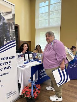 This image from the Spring Into Wellness event held on May 15 shows a community participant visiting an informational table offering healthcare materials, resources, and program brochures.